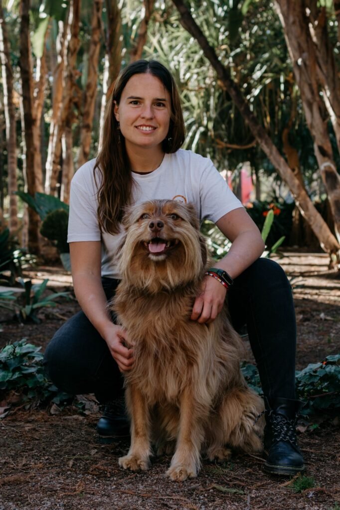 Ángela Padrón agachada junto a Kobe en un jardín